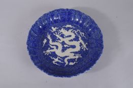 A CHINESE SACRIFICIAL BLUE AND WHITE CARVED DRAGON CHARGER. 34cms diameter.