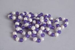 A LONG STRING OF AMETHYST AND PEARL BEADS 48ins long.