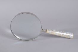 A LARGE MAGNIFYING GLASS with mother of pearl handle. 6ins diameter.