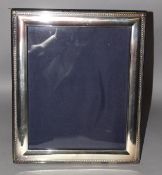 A LARGE SILVER PLATED PHOTOGRAPH FRAME. 12.5ins x 10ins.
