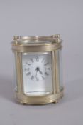 A GILT OVAL ENAMEL CLOCK. 3ins high.