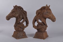 A PAIR OF CAST IRON HORSES HEADS. 14ins high.
