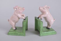 A PAIR OF PAINTED CAST IRON BOOKENDS. 5.5ins high.