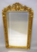 A LOUIS XVI DESIGN GILTWOOD MIRROR with cherub and scrolls. 5ft 2ins high x 2ft 8ins wide.