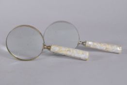 A PAIR OF MAGNIFYING GLASSES with mother of pearl handles. 4ins diameter.