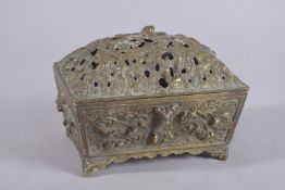 A CHINESE RECTANGULAR LIDDED BRASS CENSER, relief decorated with mythical creatures amongst stylised