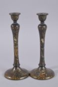 TWO PERSIAN QAJAR LACQUERED WOOD CANDLE HOLDERS, painted with figures and foliate designs, 26.5cm