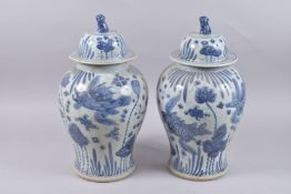 A LARGE PAIR OF CHINESE BLUE AND WHITE PORCELAIN JARS AND COVERS, painted with fish and aquatic