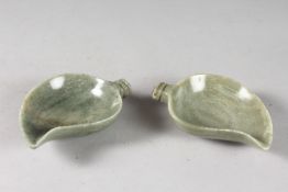 A PAIR OF EARLY 20TH CENTURY INDIAN CARVED GREEN STONE PAISLEY SHAPE BOWLS, inset with blue