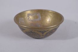 A 19TH CENTURY SYRIAN SILVER AND COPPER INLAID BRASS BOWL, 12.5cm diameter.