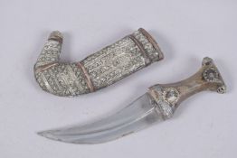 AN OMANI WHITE METAL AND LEATHER MOUNTED JAMBIYA, 24cm long.
