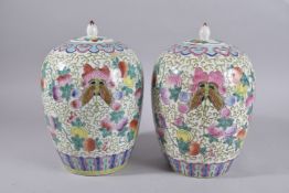 A PAIR OF CHINESE FAMILLE ROSE PORCELAIN JARS AND COVERS, painted with butterfly and peach blossom
