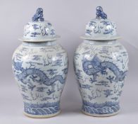 A VERY LARGE PAIR OF CHINESE BLUE AND WHITE PORCELAIN JARS AND COVERS, painted with dragons and