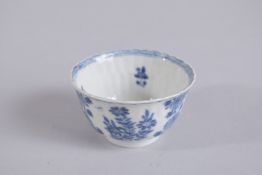 A 17TH CENTURY CHINESE KANGXI PERIOD BLUE AND WHITE PORCELAIN TEA CUP, painted with flora, mark to