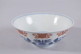 A CHINESE IRON RED, BLUE AND WHITE PORCELAIN BOWL, painted with eight immortal symbols, base with