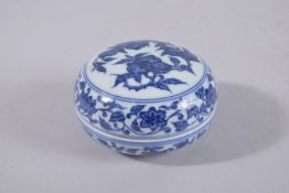 A CHINESE BLUE AND WHITE PORCELAIN CIRCULAR INK BOX, painted with peaches, bearing six-character