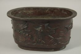 A BRONZE OVAL FORM JARDINIERE, with relief decoration of cranes, the base with character mark,