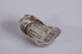 A CHINESE COIN INGOT, with impressed characters, 6cm wide.