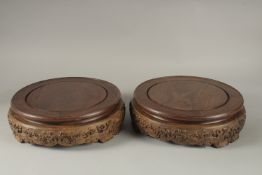 A FINE PAIR OF LARGE CHINESE HARDWOOD CIRCULAR STANDS, each top measuring 26cm diameter.