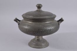 AN INDIAN MUGHAL TINNED COPPER LIDDED TWIN HANDLE BOWL, with engraved foliate decoration, 30cm