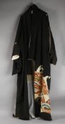A JAPANESE EMBROIDERED BLACK SILK ROBE, with various gilt and floral designs to lower section.