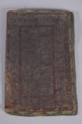 A PERSIAN QAJAR EMBOSSED LEATHER BOOK COVER, with calligraphy and floral designs, 27cm x 18cm.