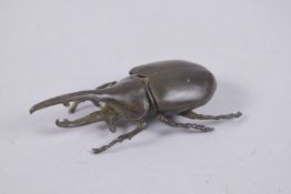 A BRONZE OKIMONO OF A RHINO HORN BEETLE.