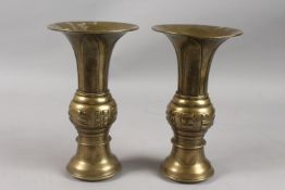 A PAIR OF CHINESE BRASS GU SHAPE VASES, with engraved designs, 26cm high.