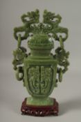 A LARGE CHINESE CARVED GREEN HARDSTONE LIDDED VASE, with twin drop ring handles and carved with