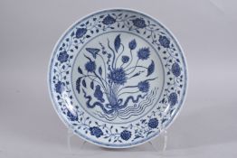 A CHINESE BLUE AND WHITE PORCELAIN CHARGER, decorated with central floral spray, bearing six-
