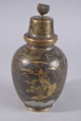 A JAPANESE GILDED METAL LIDDED JAR, with decorative panels; one depicting a boat on water, the