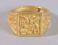 A CHINESE YELLOW METAL RING.