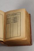 A FINE 19TH CENTURY POSSIBLY PERSIAN LEATHER BOUND SMALL QURAN, signed and dated, 1308 HD / 1890 AD,