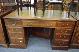 A mahogany twin pedestal desk with green leather inset top.