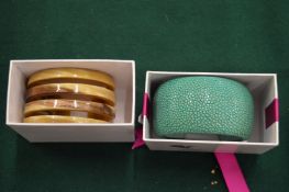 A Cuckoo Moment horn bangle and faux chagreen bangle.