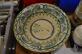 A large Continental earthenware bowl with blue and green painted decoration.