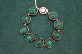 A silver and cabochon jade bracelet.