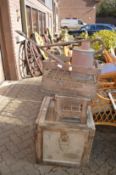 An old watering can, two old wooden bottle crates and a storage crate.