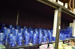 A large quantity of moulded blue glassware to include pedestal drinking cups, bowls, plates etc.