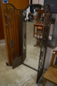 A folding wrought iron framed mirror.