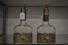 A good pair of engraved and etched glass decanters with decorative white metal mounts.
