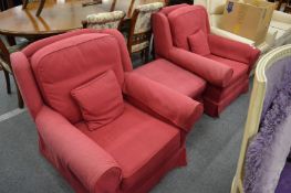 A pair of red upholstered armchairs and matching footstool.