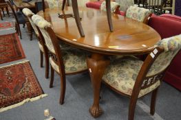 A mahogany extending dining table with two leaves supported on cabriole legs with claw and ball