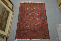 A small Persian Bokhara style rug, 110cm x 75cm.