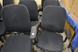 A set of six office swivel armchairs.