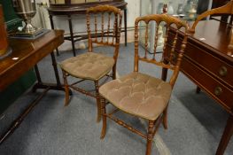 A pair of beech framed spindle back occasional chairs with painted decoration.