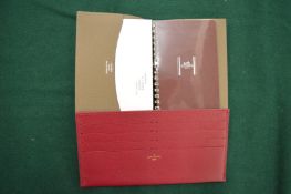 A Hermes leather cased note pad and a Louis Vuitton red leather credit card holder.