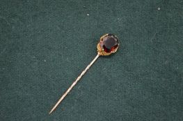 A gold and gem set tie pin.