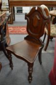 A 19th century mahogany hall chair with shield shape back.