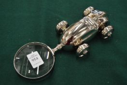 A novelty magnifying glass with racing car handle.